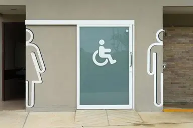 An accessible toilet between two other public toilets