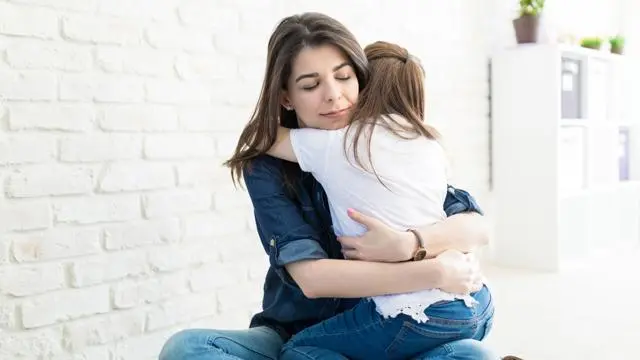 Mother hugging daughter